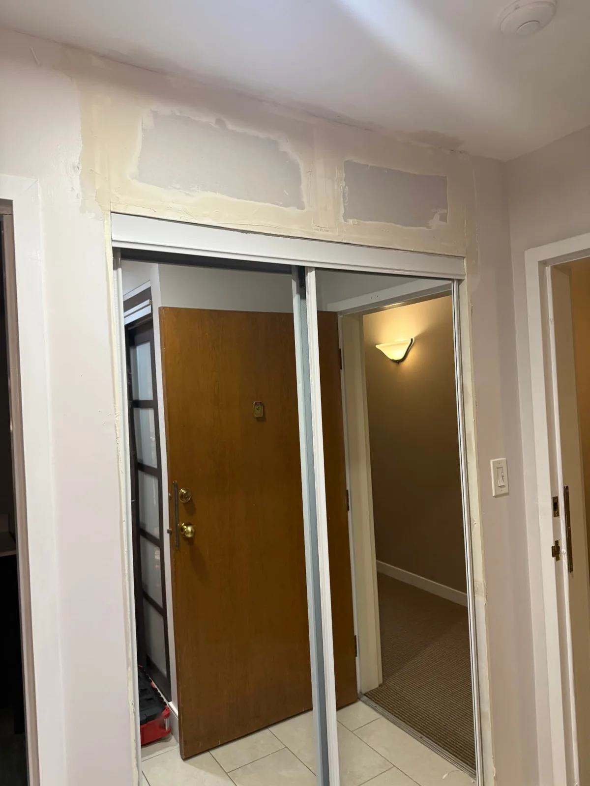 Installation — mirrored doors fitted and wall finishing underway.