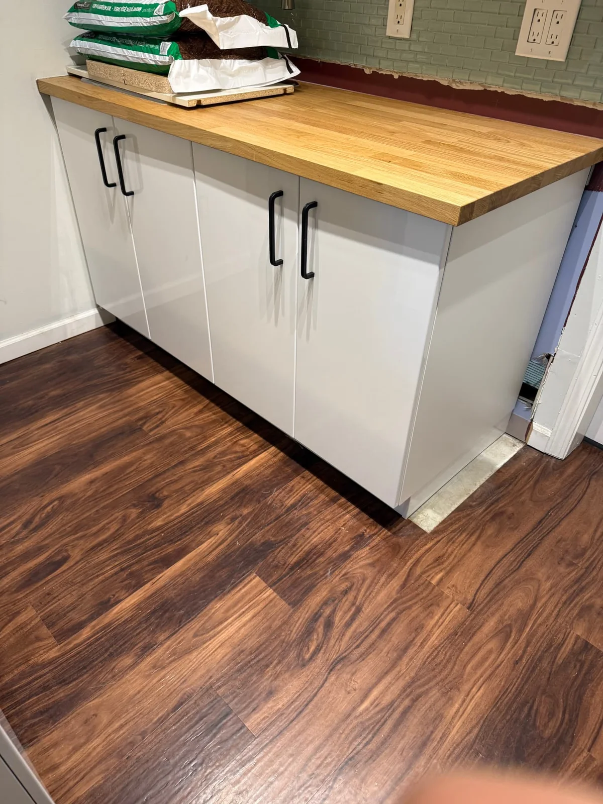 After — finished cupboard cabinets with wood countertop and modern hardware.